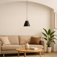 Black metal pendant light with gold interior enhancing cozy living room decor with warm ambiance.