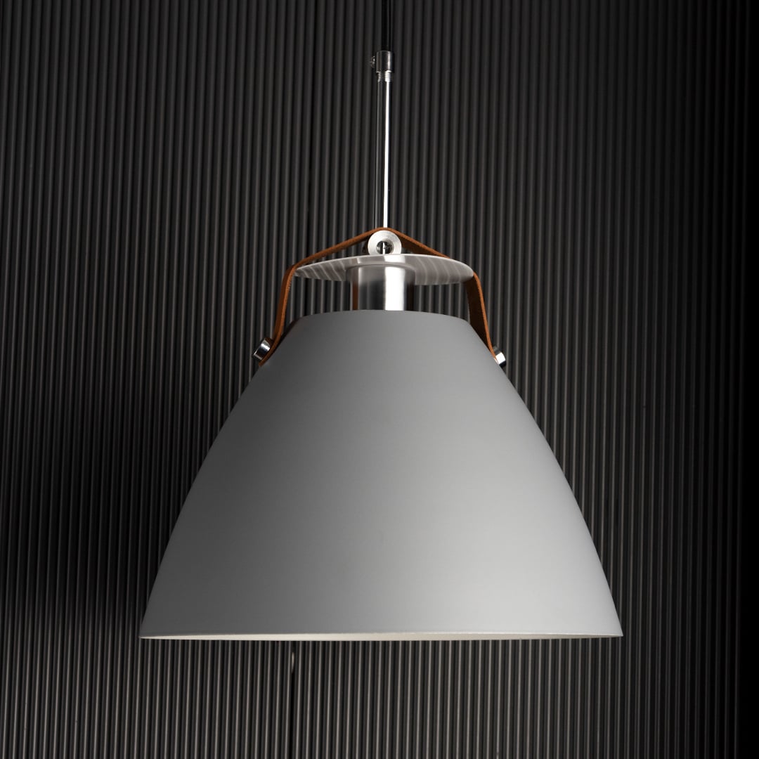 Grey pendant light turned on against dark background emphasizing its soft matte finish and refined minimalist design.