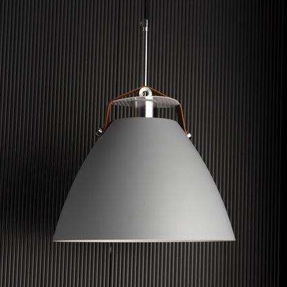 Grey pendant light turned on against dark background emphasizing its soft matte finish and refined minimalist design.