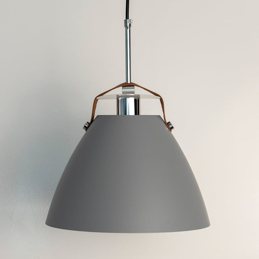 Grey pendant light off white background featuring matte conical shade and sleek metal rod with leather strap detail.