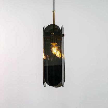 Grey glass pendant light displayed with light on against a dark background enhancing its warm illumination reflective finish and gold detailing.