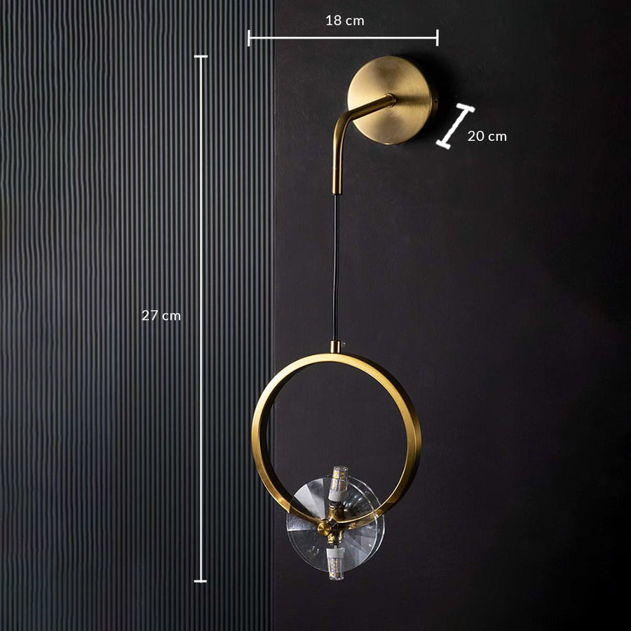 Detailed closeup of gold ring wall light highlighting its circular metal frame and polished glass element for luxury contemporary interior lighting.