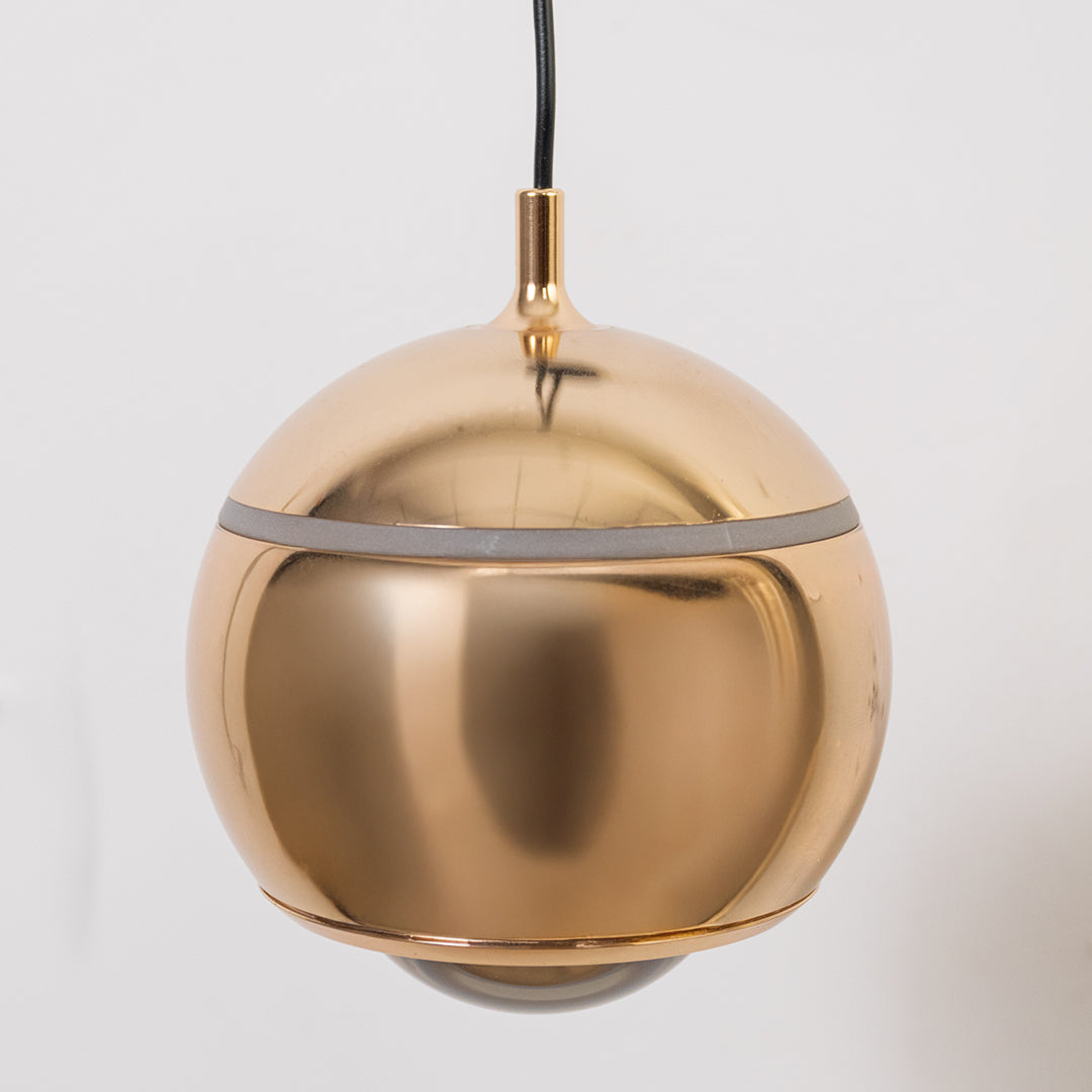 Contemporary brass pendant wall light with spherical metallic shade for luxury modern interior styling.