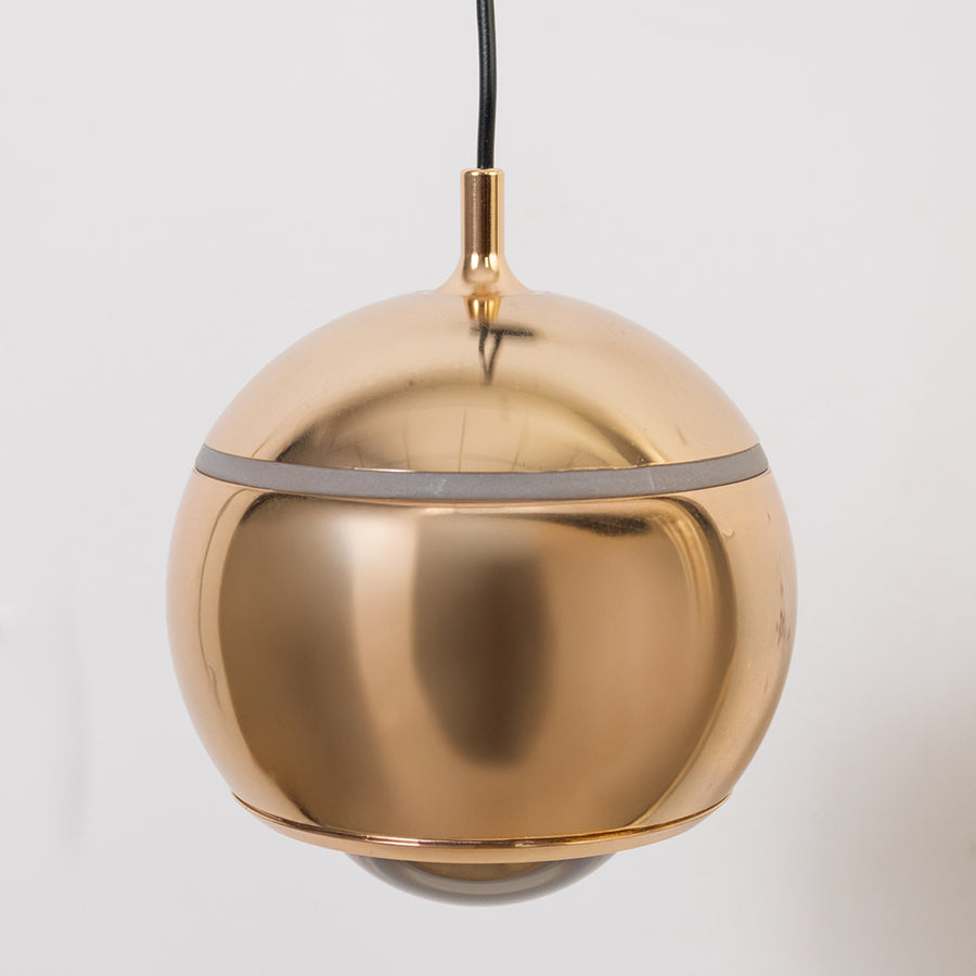 Contemporary brass pendant wall light with spherical metallic shade for luxury modern interior styling.