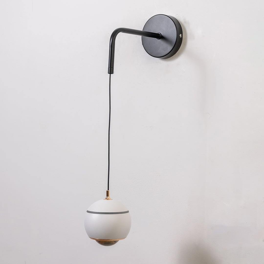Table lamp style wall light shown with the light off on a plain white background featuring a smooth globe shade for elegant modern interiors.