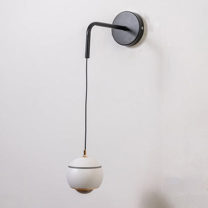 Table lamp style wall light shown with the light off on a plain white background featuring a smooth globe shade for elegant modern interiors.