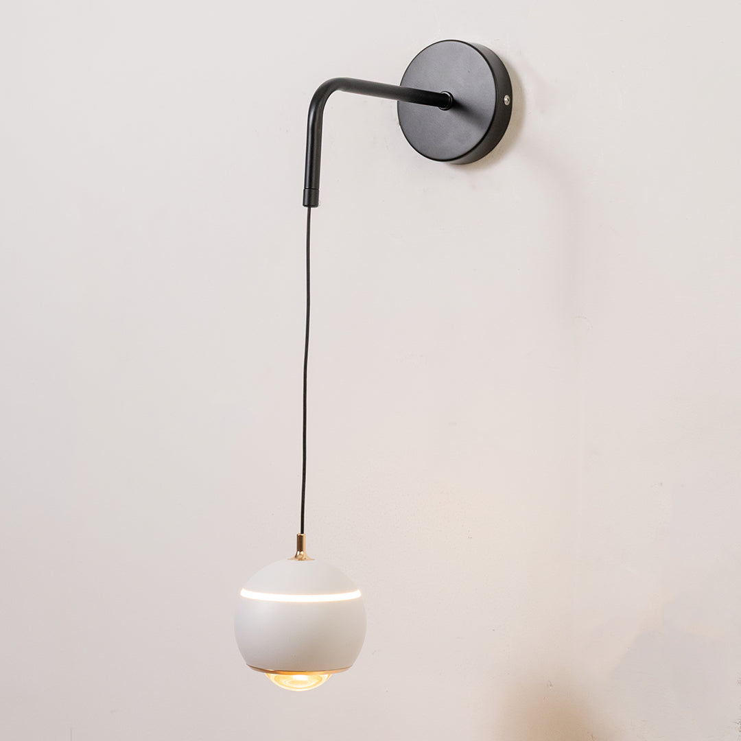 Closeup wall light in black metal finish with hanging glass shade for bedroom or living decor lighting white background.