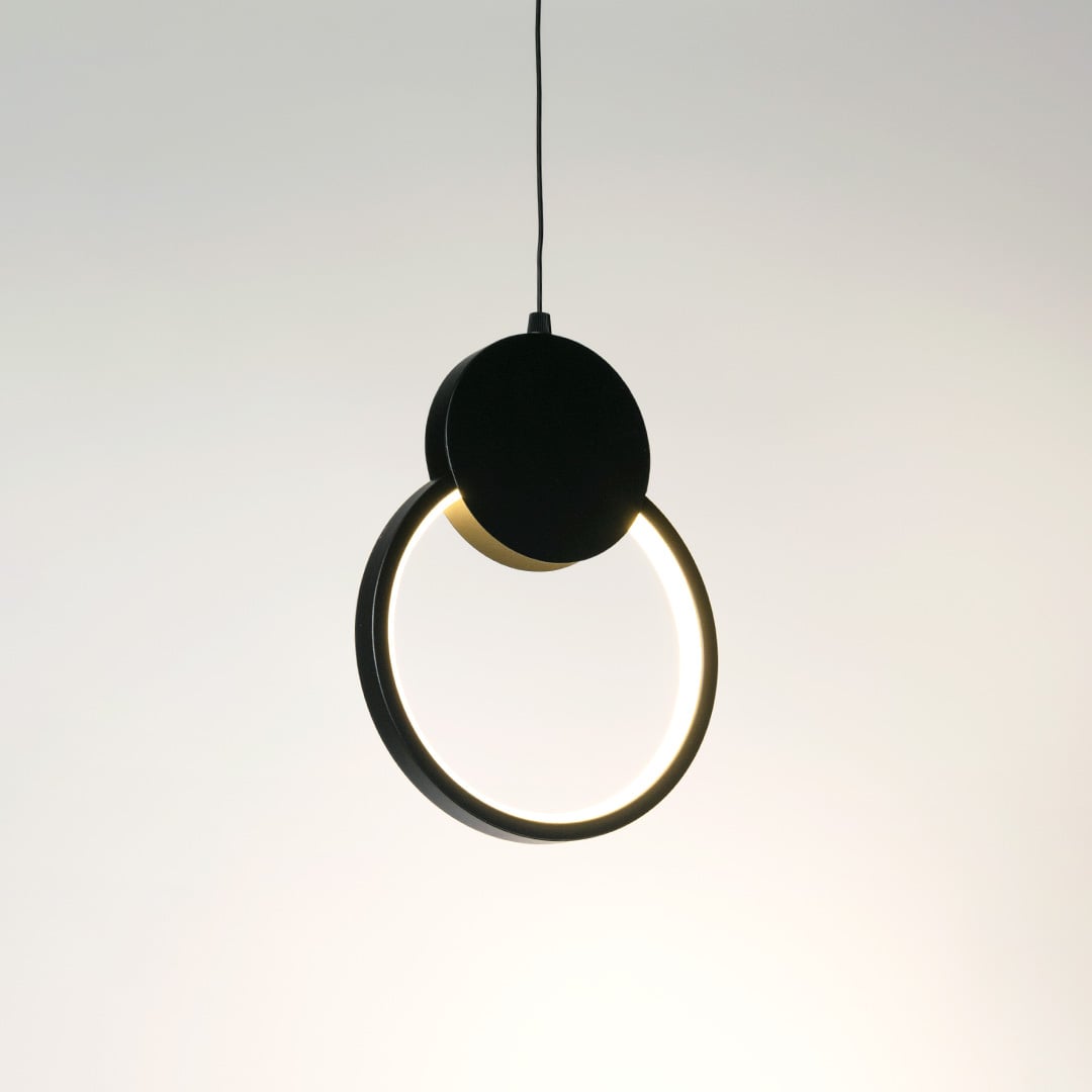 Gold pendant light with frosted glass shade glowing warmly styled in traditional living room interior with cozy wall design.