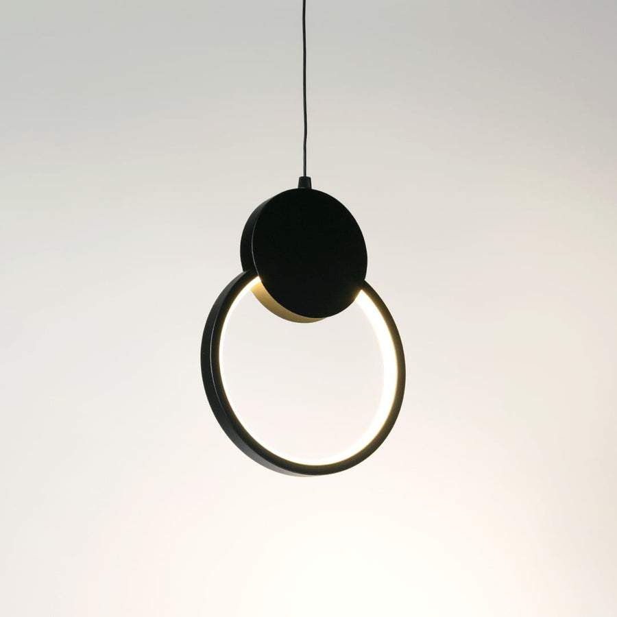 Gold pendant light with frosted glass shade glowing warmly styled in traditional living room interior with cozy wall design.