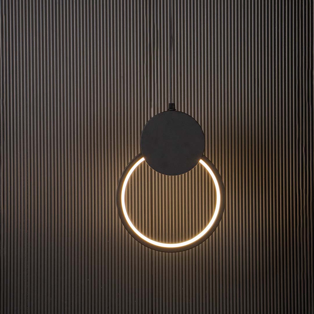 Modern black circular LED pendant light glowing brightly on black background ideal for stylish home interiors.