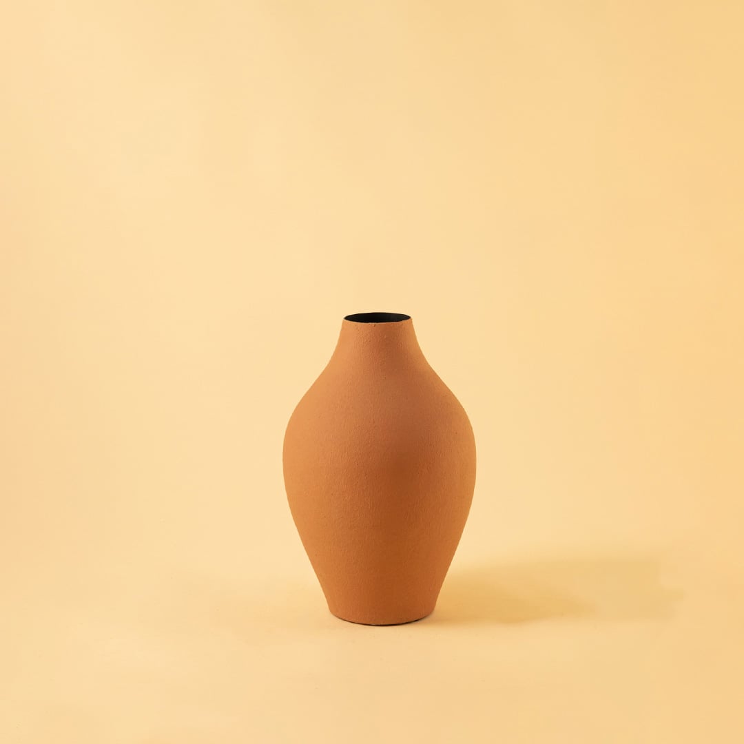 A matte beige vase shaped with gentle curves captured against a clean light background with dried branches adding a calm natural and stylish decor look.
