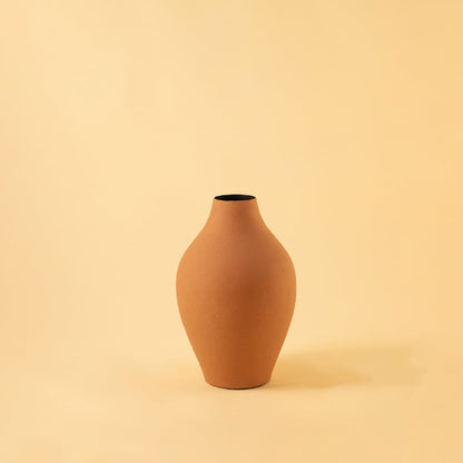 A matte beige vase shaped with gentle curves captured against a clean light background with dried branches adding a calm natural and stylish decor look.