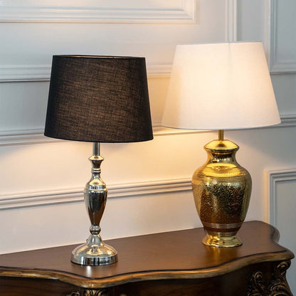 Black and gold metal table lamp with a fabric shade displayed in a warm interior with vintage decor for a luxurious touch.