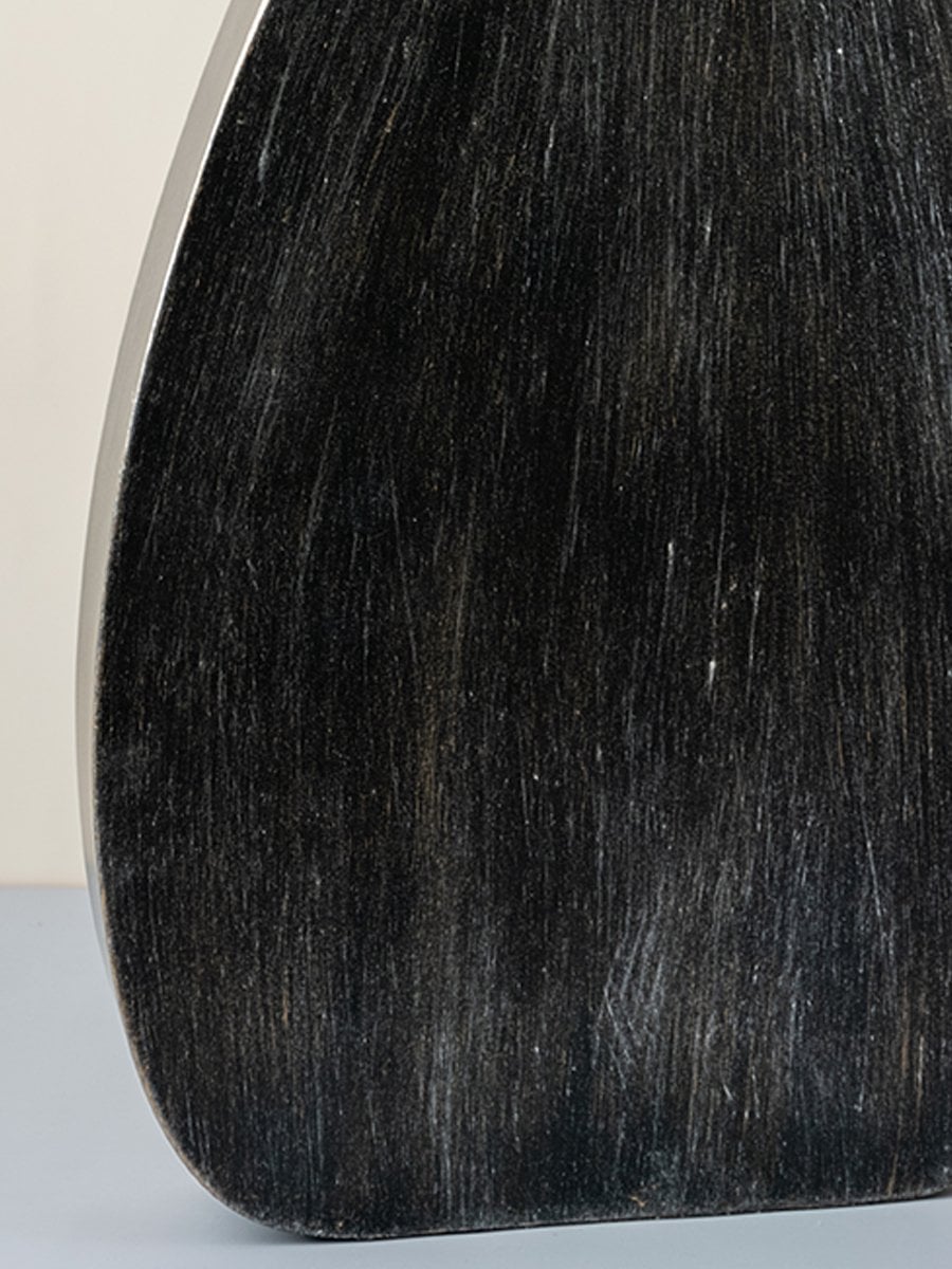 Detailed closeup of tall black wooden vase highlighting matte textured surface for contemporary decor styling.