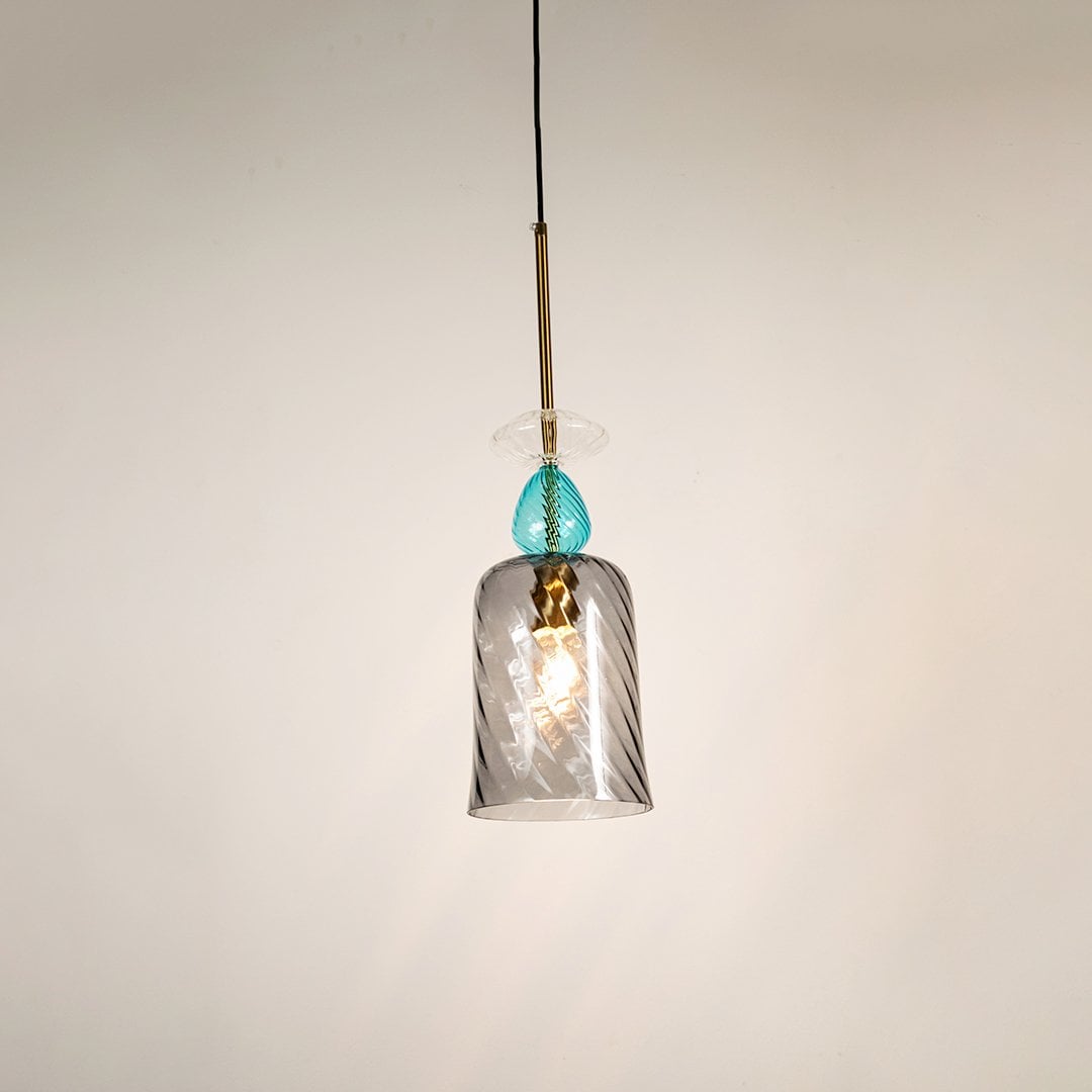 Elegant glass pendant light with glowing grey glass shade and blue top detail shining beautifully against a clean white background.