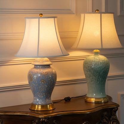 Blue and green ceramic table lamps with fabric shades styled on a console table creating elegant classic decor lighting.