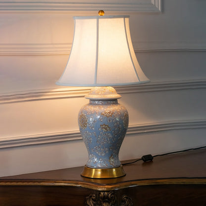 Blue ceramic table lamp with fabric shade and gold base for elegant modern lighting decor styling ideas.