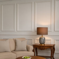 Elegant grey marble table lamp with brown fabric shade styled in a luxury living room decor.