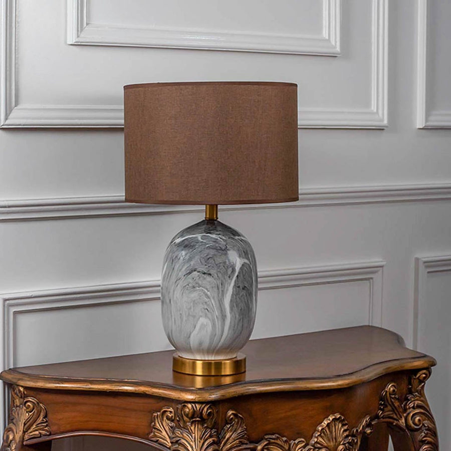 Marble base table lamp with fabric shade turned off against white background for home decor.