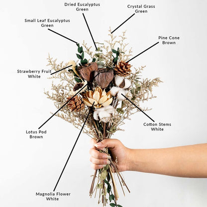 Decorative dried bouquet featuring cotton stems lotus pod magnolia flower pine cone strawberry fruit and eucalyptus greenery.