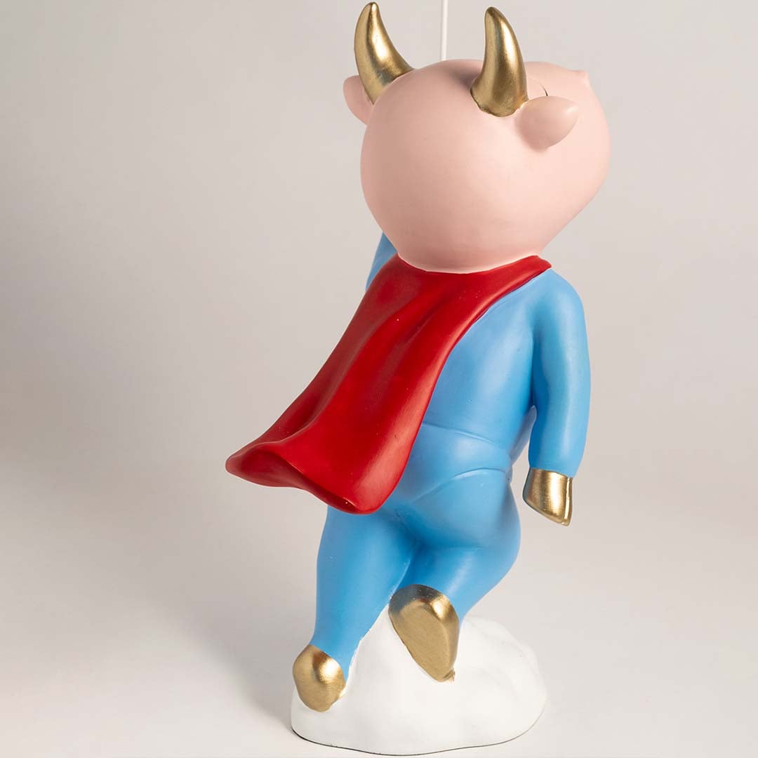 Side view of a decorative superhero inspired figurine standing on a white cloud with a blue suit red cape gold details and a gold balloon held high creating a playful display element.