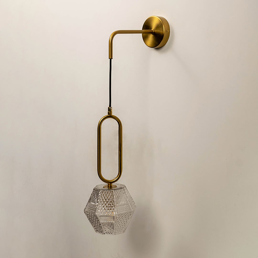 Contemporary brass pendant wall light with textured crystal glass shade for elegant modern interiors.
