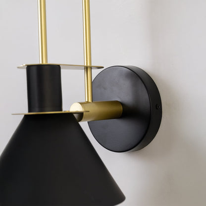 Closeup of black and gold wall light showing sleek conical shade and premium metal craftsmanship for interiors.