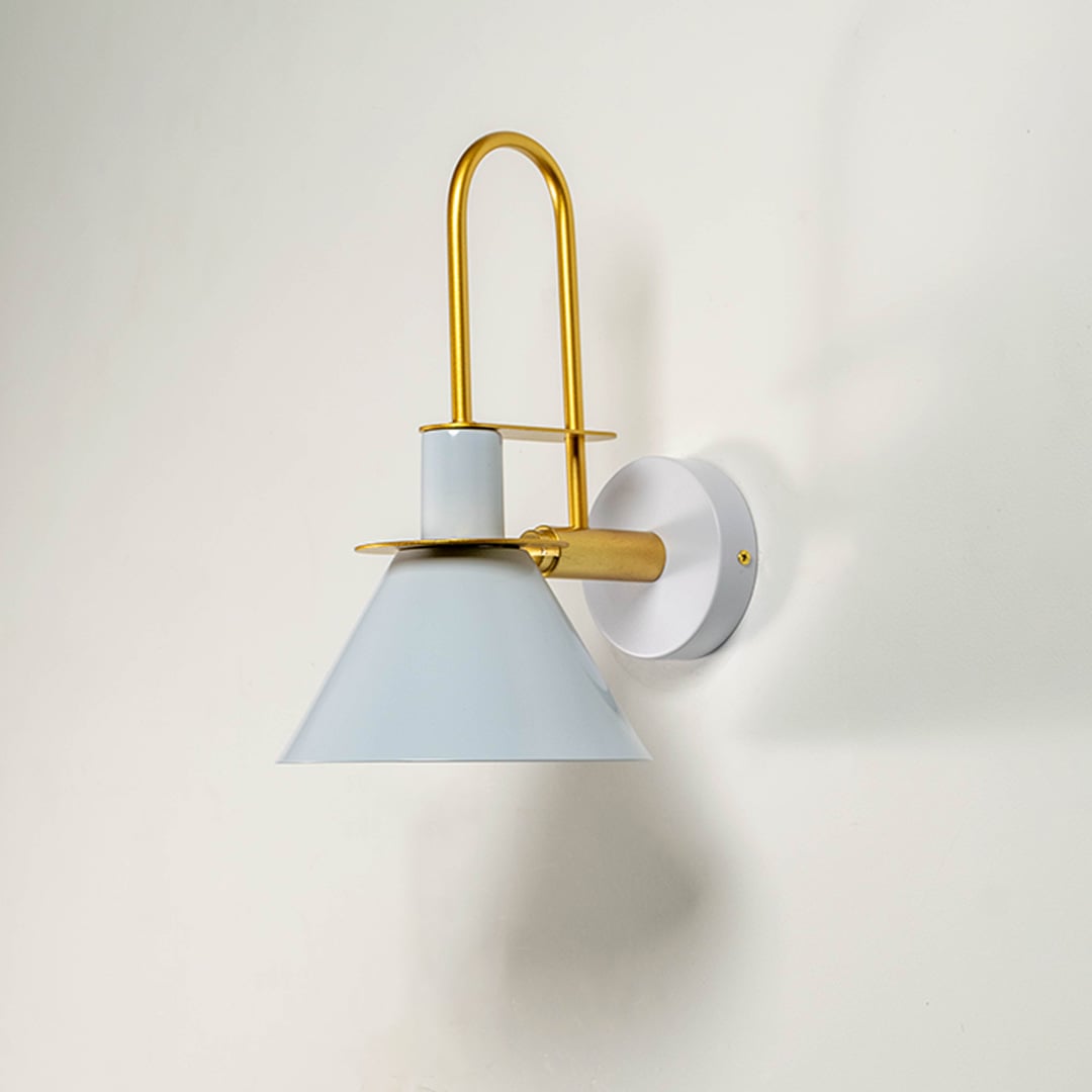 White and gold wall light with sleek conical shade displayed on white wall background for minimalist interiors.