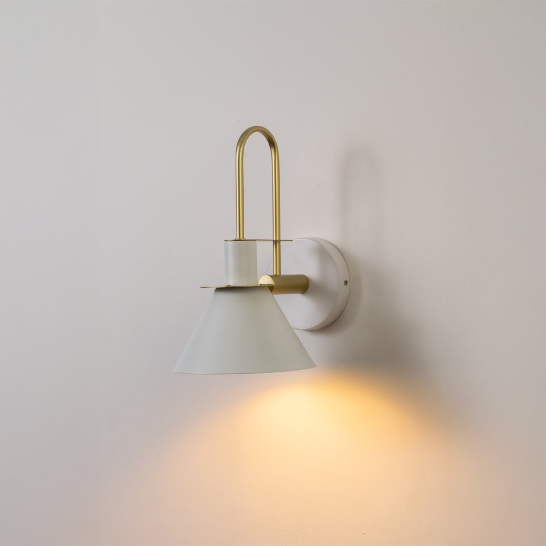 Modern white metal spotlight wall light with brass accents for warm elegant interior lighting decor.
