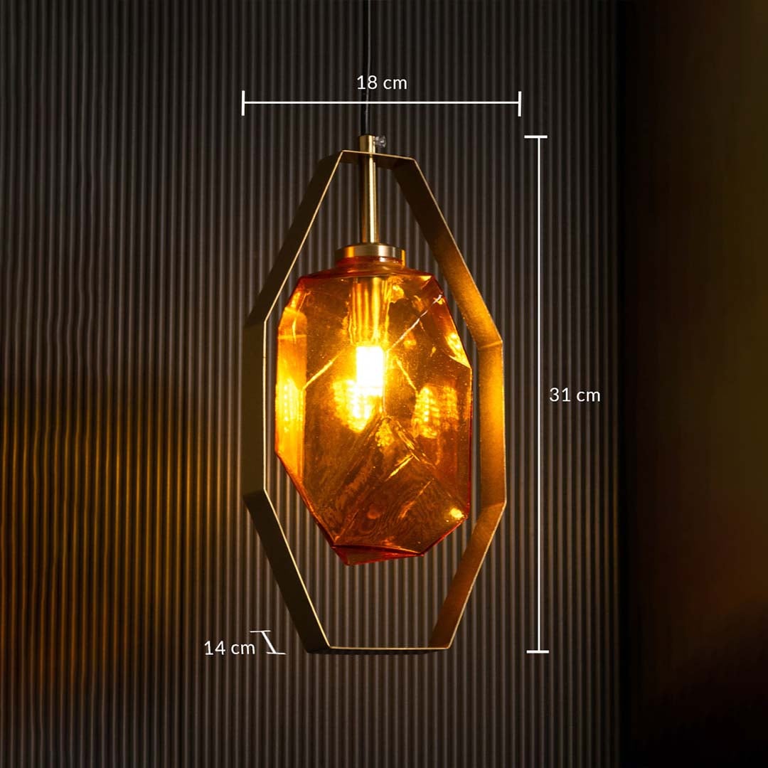 Closeup view of faceted amber glass texture and brushed gold hexagonal metal frame of modern pendant lamp showing premium craftsmanship.
