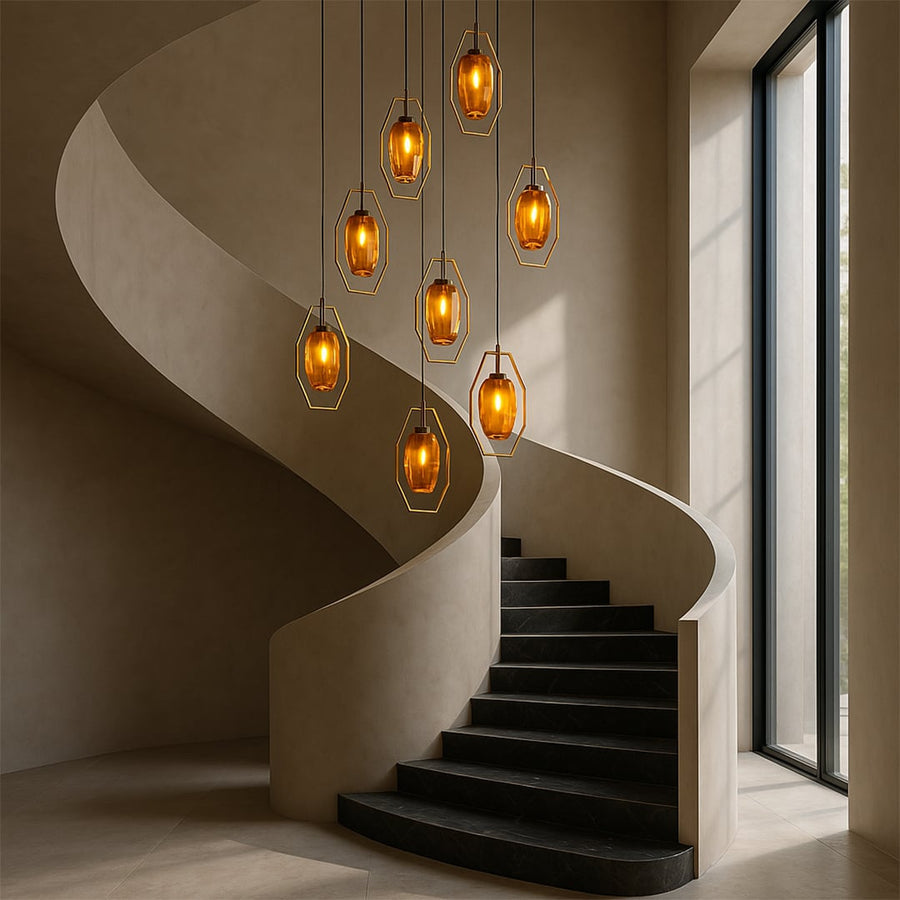 Cluster of gold geometric pendant lights with amber rock glass hanging in spiral staircase void creating luxury modern grand entrance.