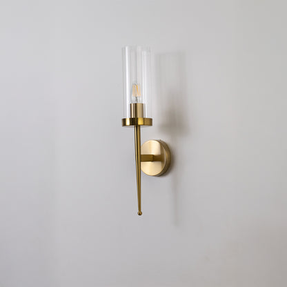 Contemporary brass wall light with sleek clear glass shade for stylish bedroom and hallway decor.
