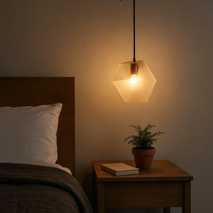 Frosted geometric pendant light on beside a wooden bed casting a warm glow that enhances minimalist bedroom decor with soft ambient illumination.