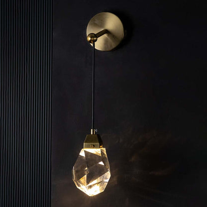 Gold and crystal pendant light glowing warmly on a dark background casting soft reflections and adding a luxurious modern lighting effect to interiors.