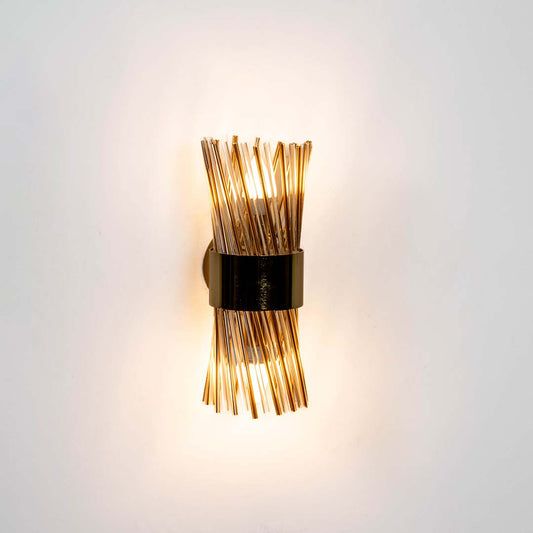 Decorative black and brass wall light with warm glow for stylish modern interior decor.