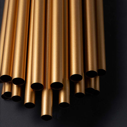A closeup of the gold metal wall light showing polished reflective metal tubes and detailed craftsmanship for luxury interior styling.