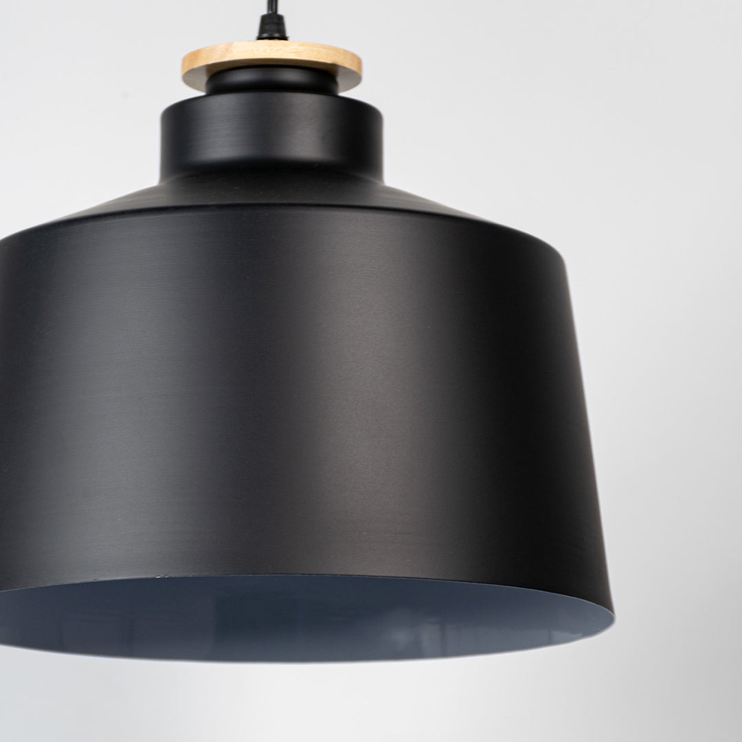 Black metal pendant light showcasing smooth matte texture and industrial drum silhouette for modern interior styling.