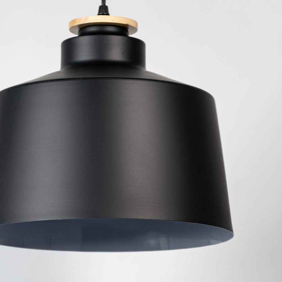 Black metal pendant light showcasing smooth matte texture and industrial drum silhouette for modern interior styling.