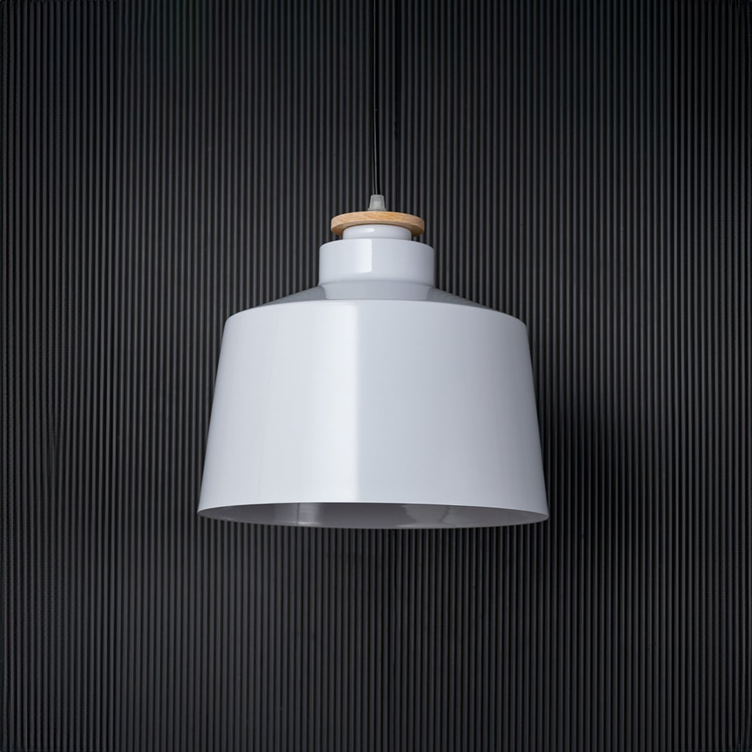 A white pendant light shown off against a black background highlighting its clean modern silhouette and smooth finish that blends effortlessly with minimalist interiors.