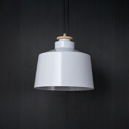 A white pendant light shown off against a black background highlighting its clean modern silhouette and smooth finish that blends effortlessly with minimalist interiors.
