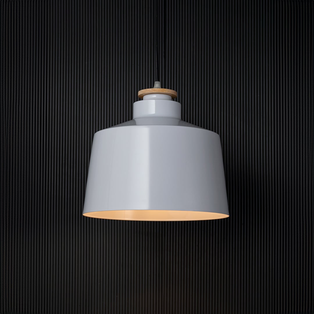 A white pendant light glowing against a black background creating a striking contrast while showcasing its smooth shade and soft warm illumination for modern decor.