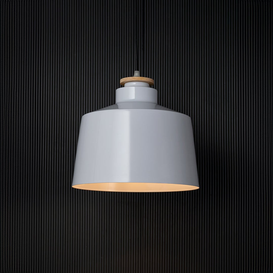 A white pendant light glowing against a black background creating a striking contrast while showcasing its smooth shade and soft warm illumination for modern decor.