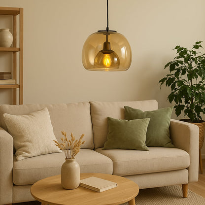 Warm amber glass pendant light hanging over a beige sofa creating soft ambient lighting perfect for living rooms and contemporary interiors.