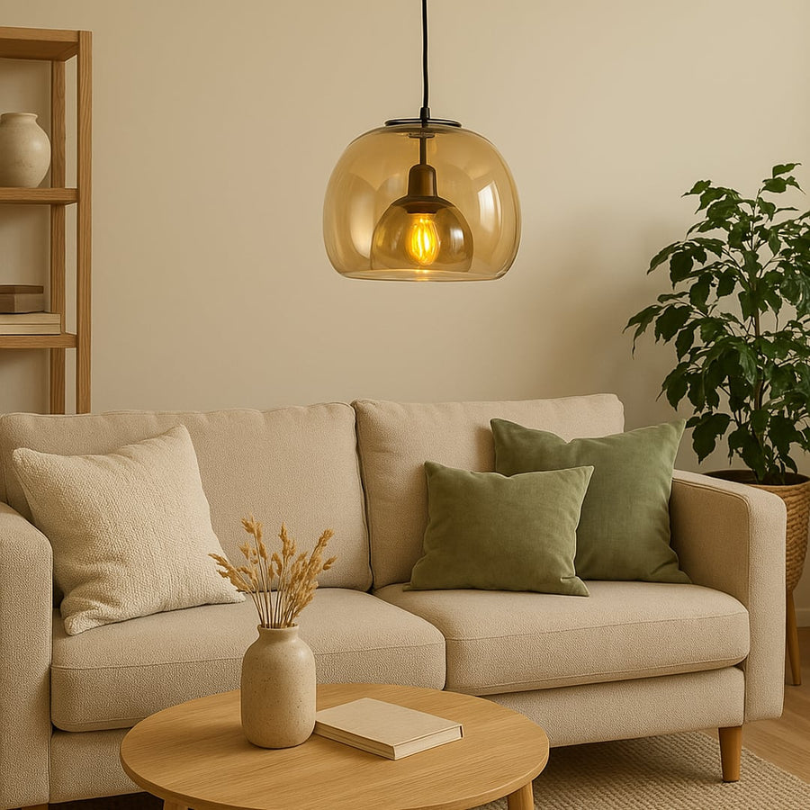 Warm amber glass pendant light hanging over a beige sofa creating soft ambient lighting perfect for living rooms and contemporary interiors.