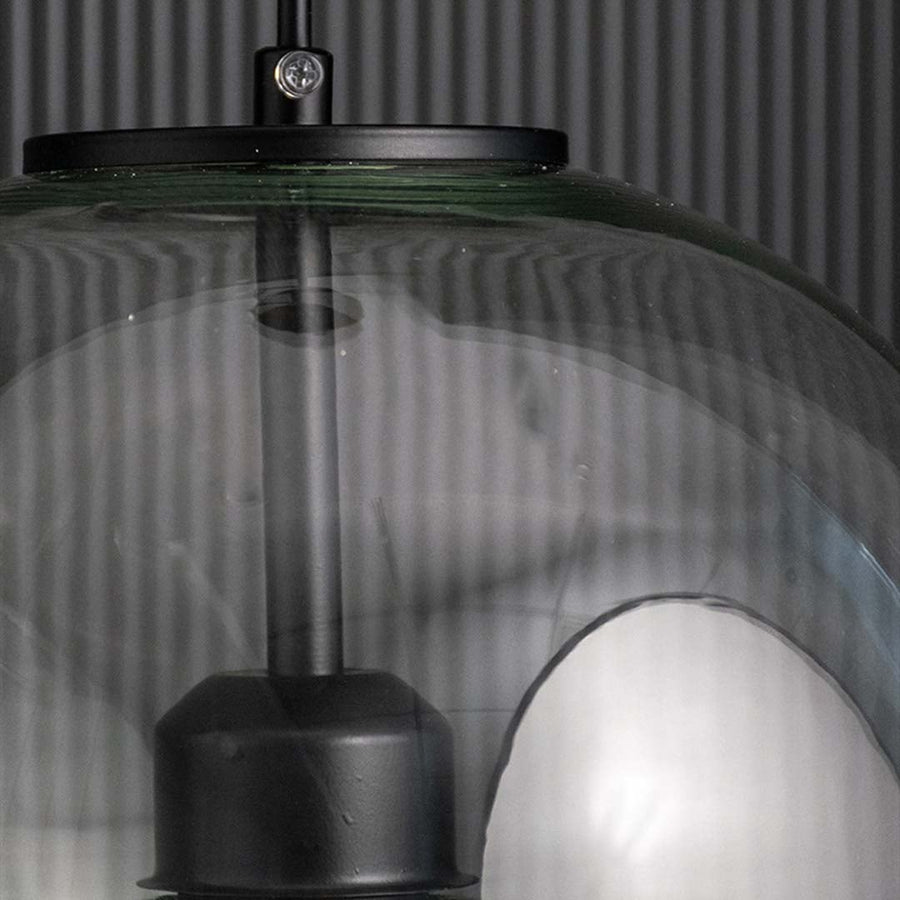 Closeup of ribbed glass pendant light top section with black metal cap showing refined texture and luxury ceiling lighting detail.