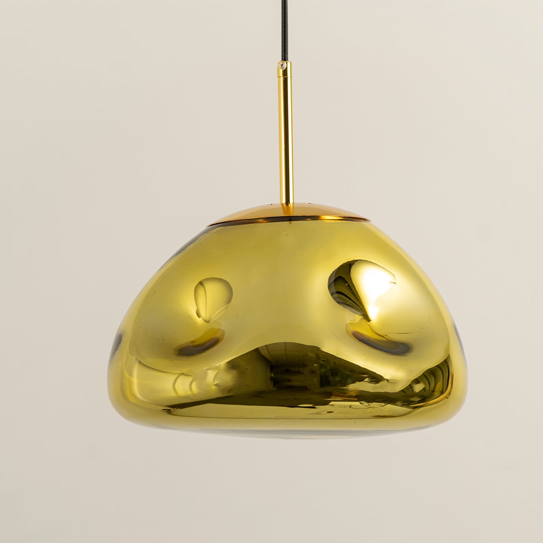 A closeup of the gold metallic pendant light highlighting its glossy curved dome surface and warm inner glow for stylish modern decor.