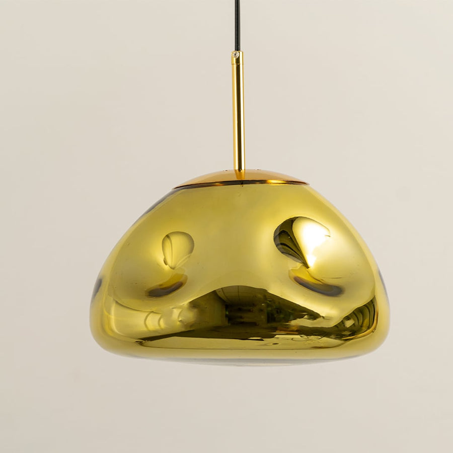 A closeup of the gold metallic pendant light highlighting its glossy curved dome surface and warm inner glow for stylish modern decor.