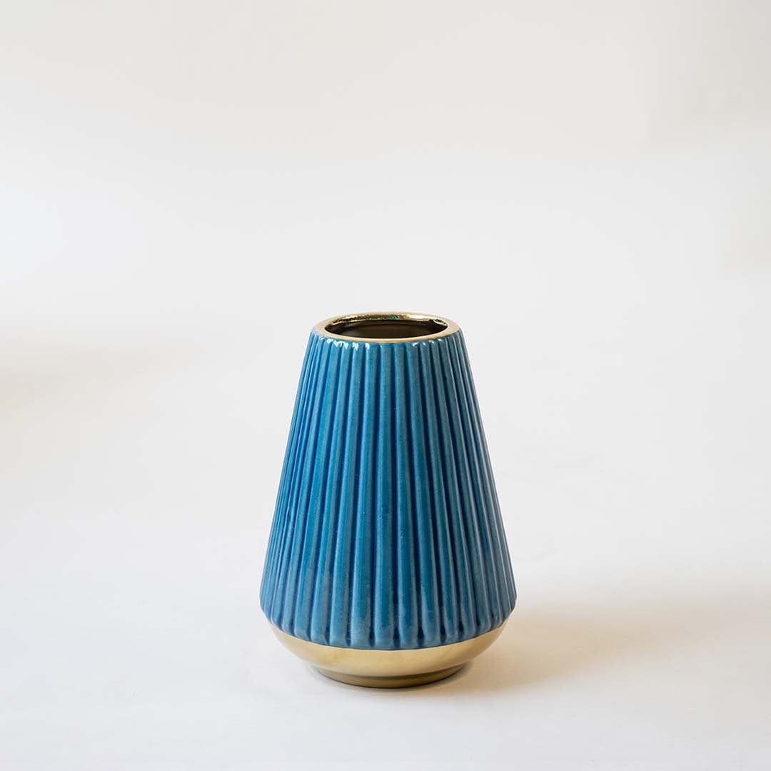 Modern blue ceramic vase with vertical ridged detailing and gold bottom displayed on a clean white background highlighting its elegant matte finish.