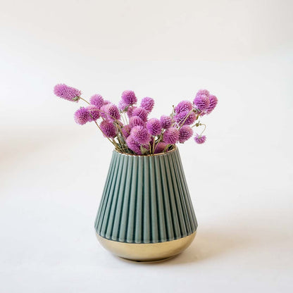 Decorative ceramic vase with ribbed green finish holding pink floral stems styled on table for modern home interior decor.