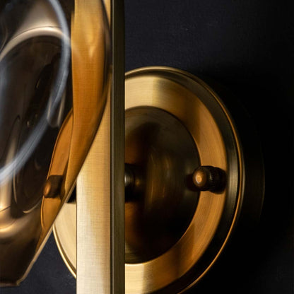 Focused closeup of the gold wall mount base showing smooth metallic texture and precision detailing for a premium finish.